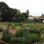 View of the museum grounds and farm beds near the entrance to the park